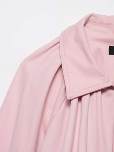 Detail of pink bomber jacket showing turnover collar and fine pleated shoulder texture