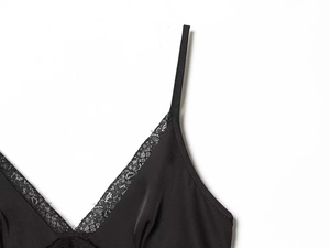 Detail of black satin camisole with delicate lace trim at the V-neckline area