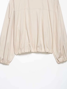 Detail view of elasticated hem and cuffs on beige striped casual shirt with smooth texture