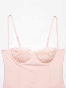 Detail shot of pink satin camisole with floral lace cups and adjustable straps