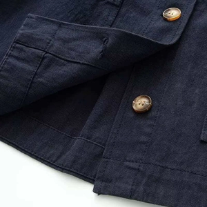 Detail of dark blue denim jacket fabric with amber buttons and double topstitching