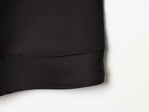 Detail view of the black satin nightgown hem showing high-quality double-stitched seams