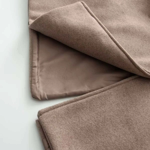 Detailed macro view of high-quality brown wool coat fabric with premium silk lining