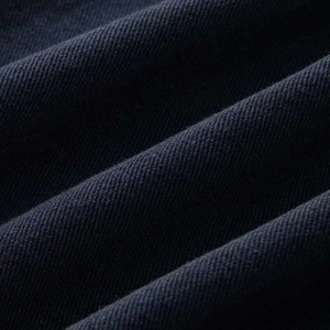 Macro shot of heavy navy blue twill denim fabric texture with clear diagonal weaving patterns
