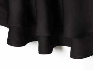 Detail of layered black satin hemline with smooth texture and high-quality stitching