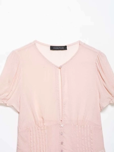 Detail of light pink chiffon top featuring V-neckline with hollow-out and pleated waist