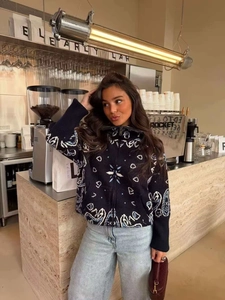 Détail du cardigan en maille vintage avec motifs paisley jacquard noir blanc et bleu
