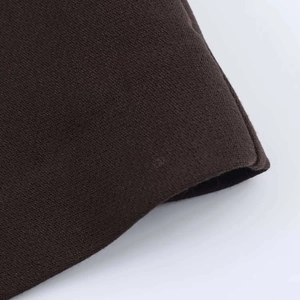 Gros plan détaillé de la texture du tricot marron foncé et des bords bien cousus