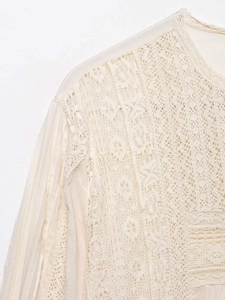 Close-up of minimalist apricot lace stitching and sheer chiffon neckline texture