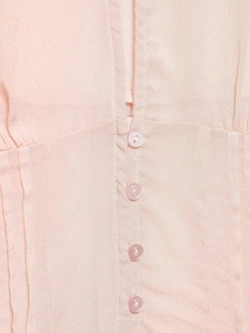 Detail of pink chiffon blouse featuring pearlescent buttons and vertical pleat texture