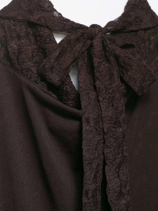 Détail du décolleté dos nu marron chocolat avec bordure en dentelle et nœud élégant