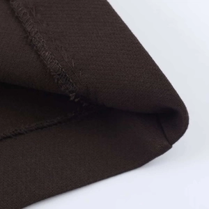 Gros plan détaillé des coutures du tissu plissé marron foncé et texture textile de qualité