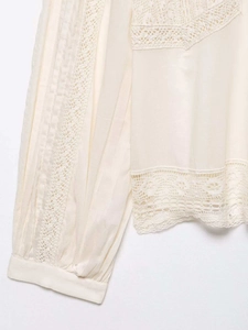 Detail of apricot chiffon top with delicate lace stitching and pleated texture design