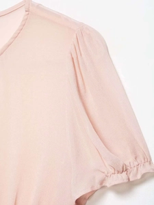 Detail of pink chiffon top showing pleated shoulder seams and delicate sleeve texture