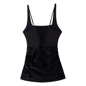 Détail du laçage croisé au dos d'une mini robe noire à paillettes avec fines bretelles