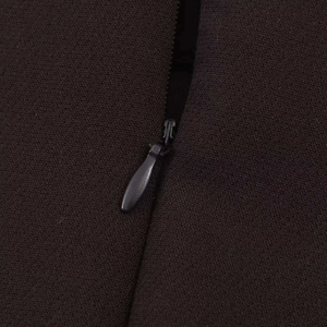 Détail macro d'un ensemble gilet noir avec fermeture éclair invisible et texture en crêpe