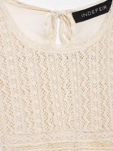 Close-up of beige lace neckline with back cutout and tie detail on chiffon top