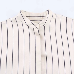 Close-up of mandarin collar and button detail on a striped summer linen-style shirt