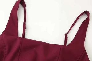 Détail du décolleté carré et des bretelles réglables sur une robe bordeaux chic