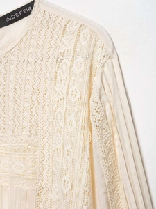 Detailed view of apricot chiffon top featuring intricate lace stitching and pleated sleeves