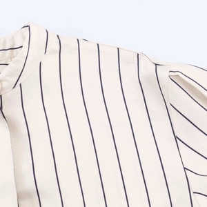 Close-up of a striped button-up shirt collar and shoulder showing fine fabric texture