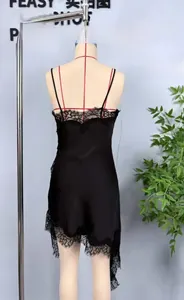 Detail of a black satin slip dress showing intricate lace trim and irregular hemline