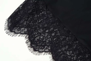 Détail de la dentelle cils noire délicate sur l'ourlet d'une robe courte chic