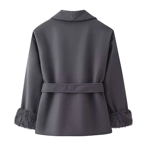 Dettaglio cappotto grigio in lana con polsini in pelliccia sintetica e cintura in vita