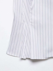 Detailed close-up of blue vertical striped cotton poplin fabric with a ruffled hem finish