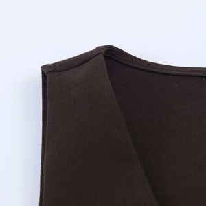 Détail de couture du col en V et texture de maille sur un ensemble de gilet marron