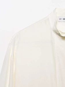 Close-up of cream satin long sleeve shirt featuring a stand collar and smooth texture