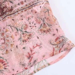 Gros plan sur un tissu mousseline léger avec motifs paisley roses et fleurs bohémiennes