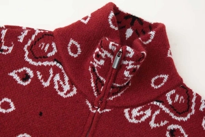 Gros plan du cardigan en tricot rouge foncé avec motif jacquard paisley et zip argenté