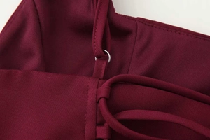 Détail de bretelles réglables avec anneaux métalliques sur une robe pailletée bordeaux
