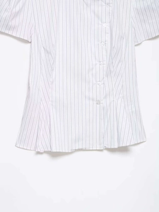Detail of blue striped poplin shirt showing button closure and pleated waist design