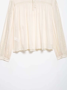 Detail view of elegant lace patchwork and ties on this beige chiffon blouse for women