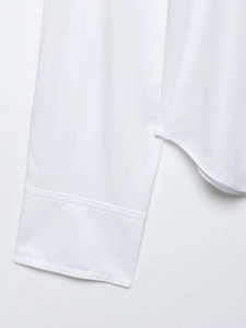 Detail of white cotton shirt showing wide cuffs and curved side seam hem stitching