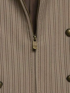 Detailaufnahme von braunem Nadelstreifen-Blazerstoff mit Metallreißverschluss und Knöpfen