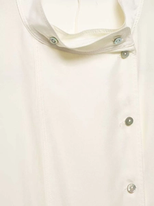 Detailed shot of mandarin collar and iridescent shell buttons on an ivory linen shirt