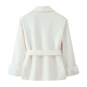 Dettaglio del retro di un cappotto bianco con cintura in vita e polsini in ecopelliccia