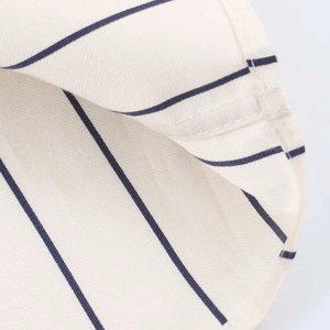 Close-up of ivory fabric with blue vertical stripes and premium double-needle stitching