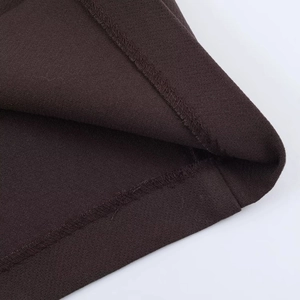 Close-up of the fine ribbed texture and professional stitching on the dark brown knit fabric