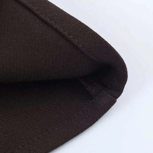 Détail rapproché du tissu en maille marron foncé avec ourlet cousu et texture fine