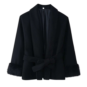 Dettaglio del cappotto di lana nero con polsini in pelliccia e cintura a fiocco chic