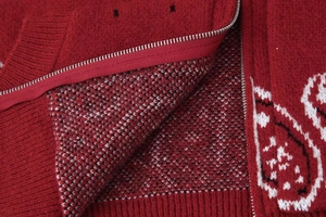 Détail de la maille jacquard cachemire et de la fermeture éclair sur ce gilet rouge foncé
