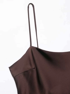 Close-up of thin straps and silky brown satin fabric on this elegant summer slip dress
