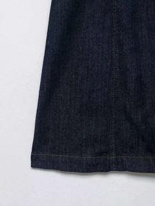 Detailed macro view of dark blue denim fabric with contrast orange topstitching craft