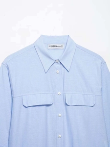 Close-up of light blue striped shirt featuring double chest pockets and pointed collar
