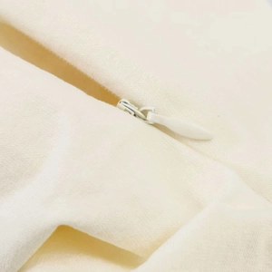 Detailed view of hidden zipper on ivory pleated bandeau top with soft textured fabric