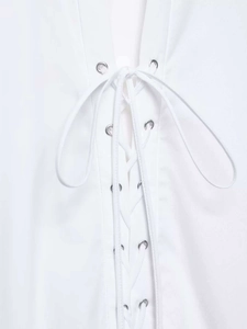 Detail of white shirt with metal eyelets and cross lace-up design for women